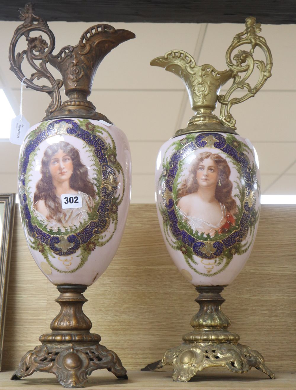 A pair of spelter-mounted porcelain ewers, height 64cm